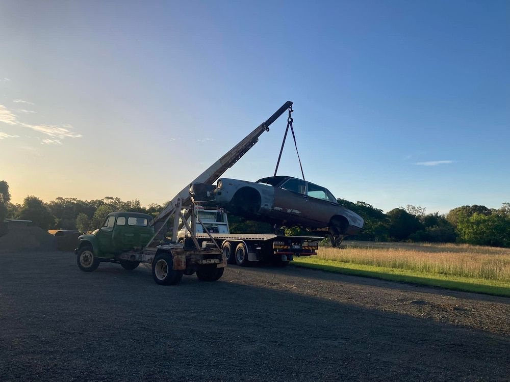 A Tow Truck Is Carrying A Car On A Flatbed Trailer — Little Mates Towing & Transport Pty Ltd In Gladstone, QLD