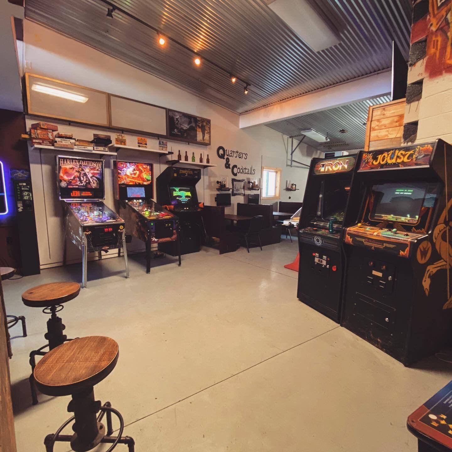 A room filled with arcade machines including one that says louise