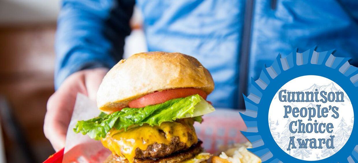 A person is holding a hamburger in their hand.