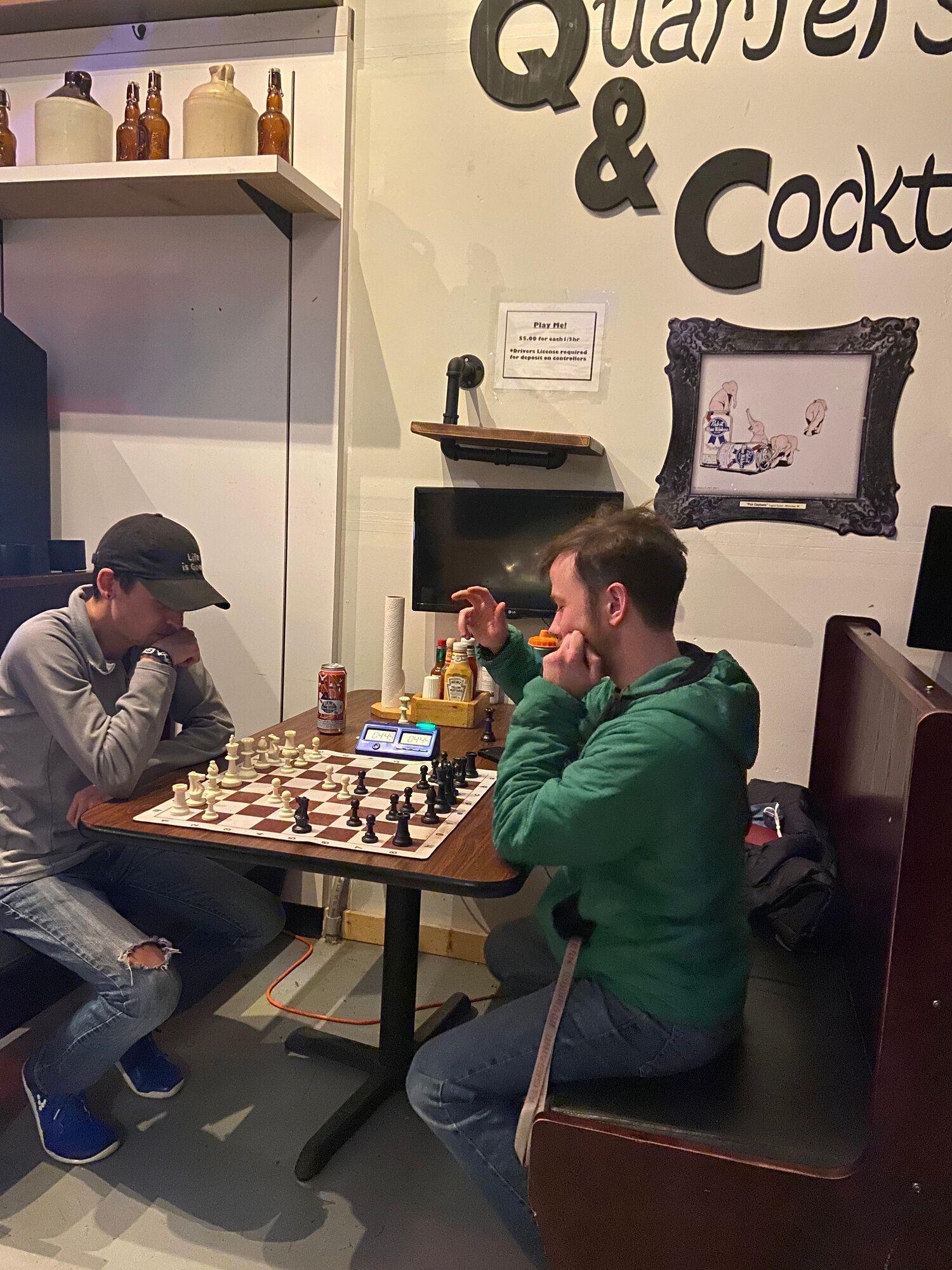 Two men are sitting at a table playing chess.