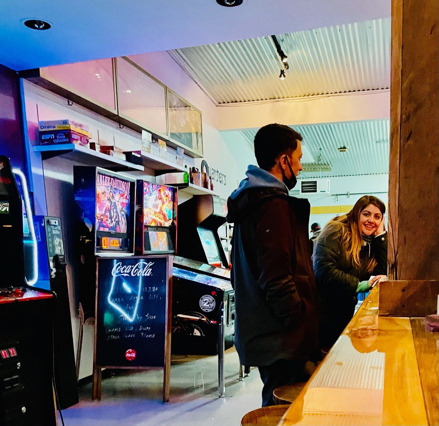 A man standing in front of a sign that says arcade