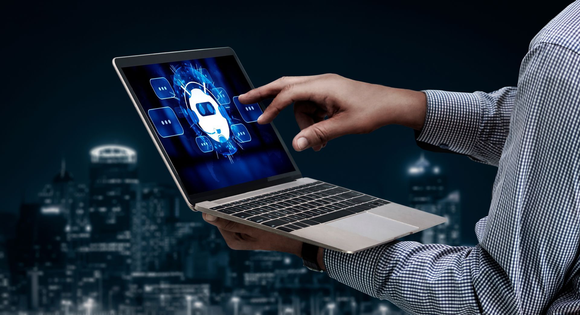 A person in a plaid shirt touches a laptop screen displaying a glowing, digital vehicle icon against a dark city backdrop.