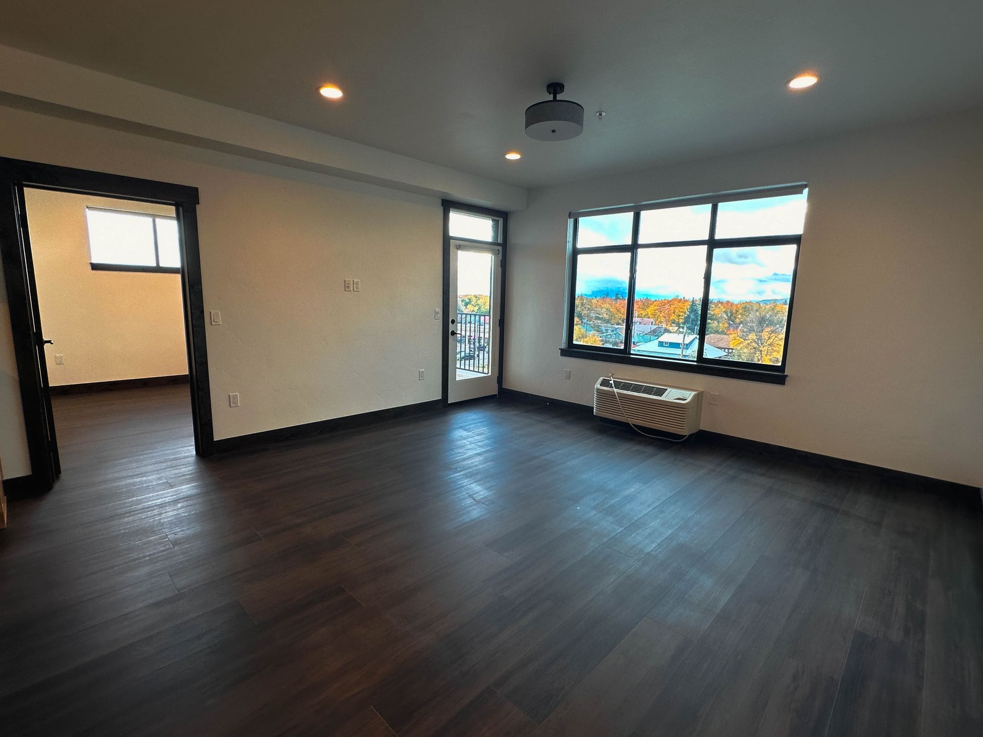 an empty room with a window and a heater