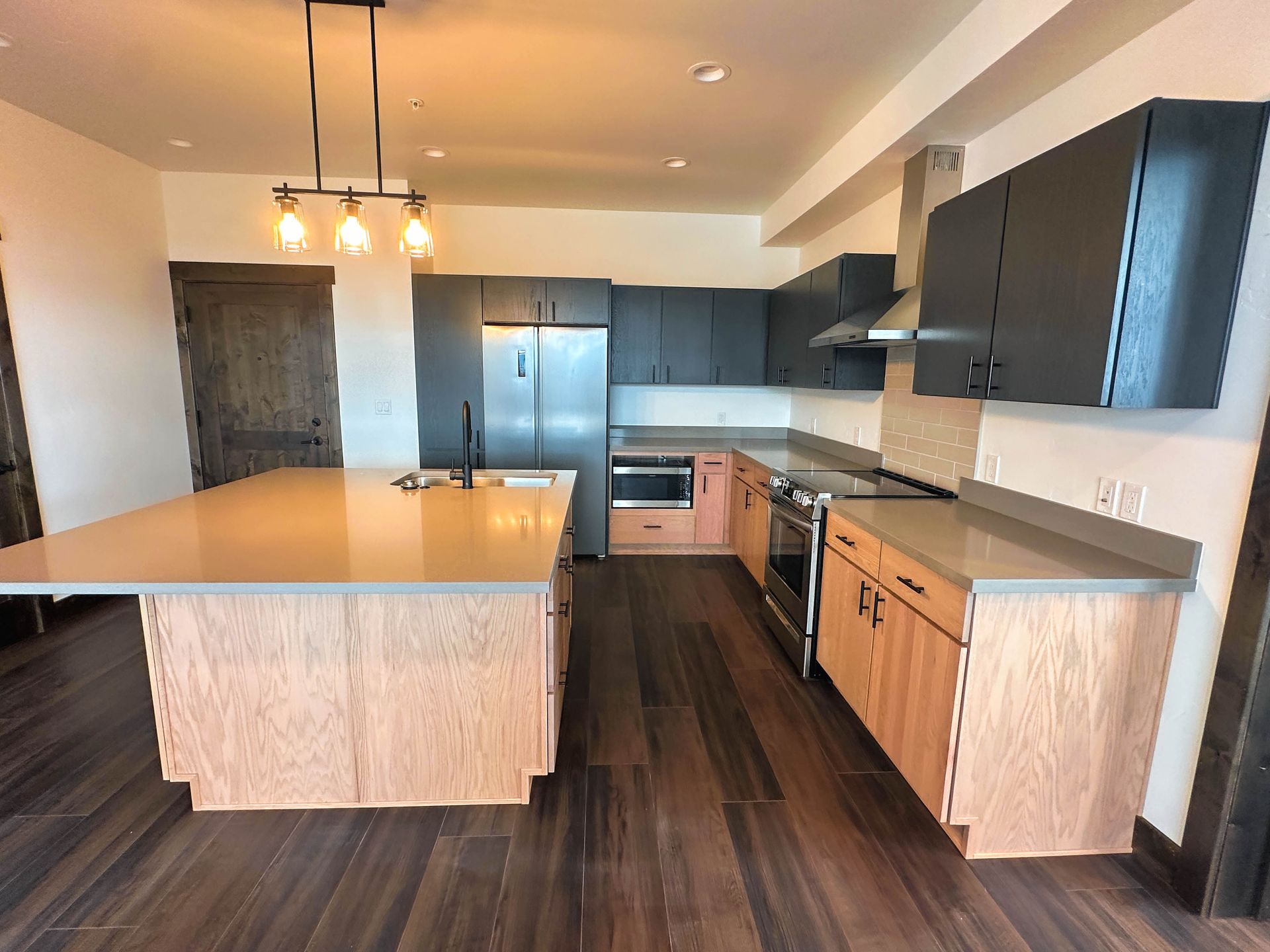 a kitchen with a large island and stainless steel appliances