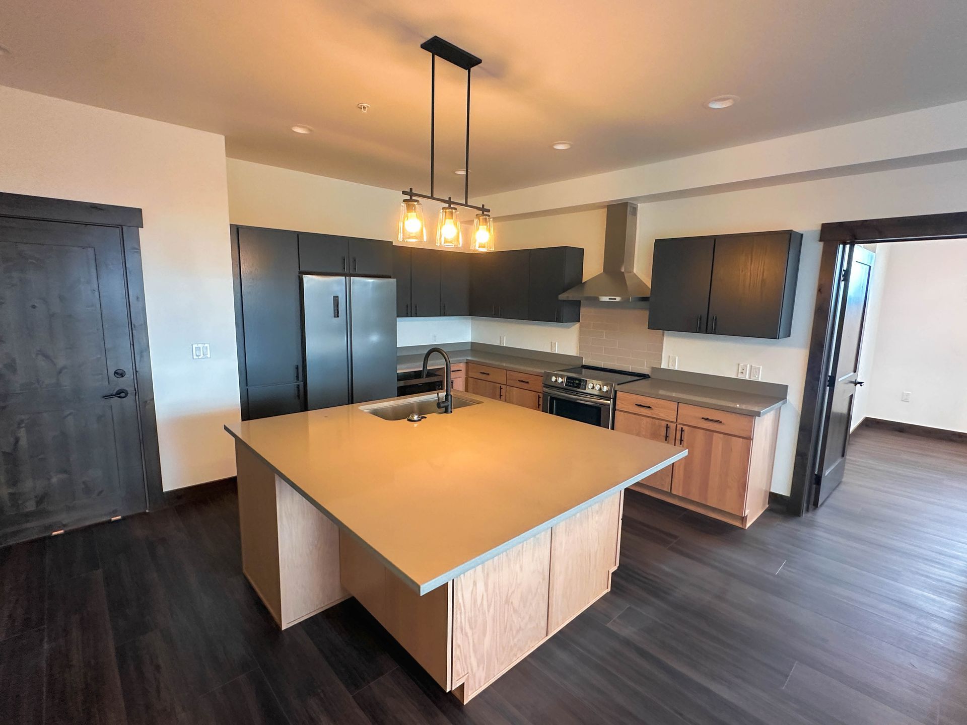 a kitchen with a large island and stainless steel appliances