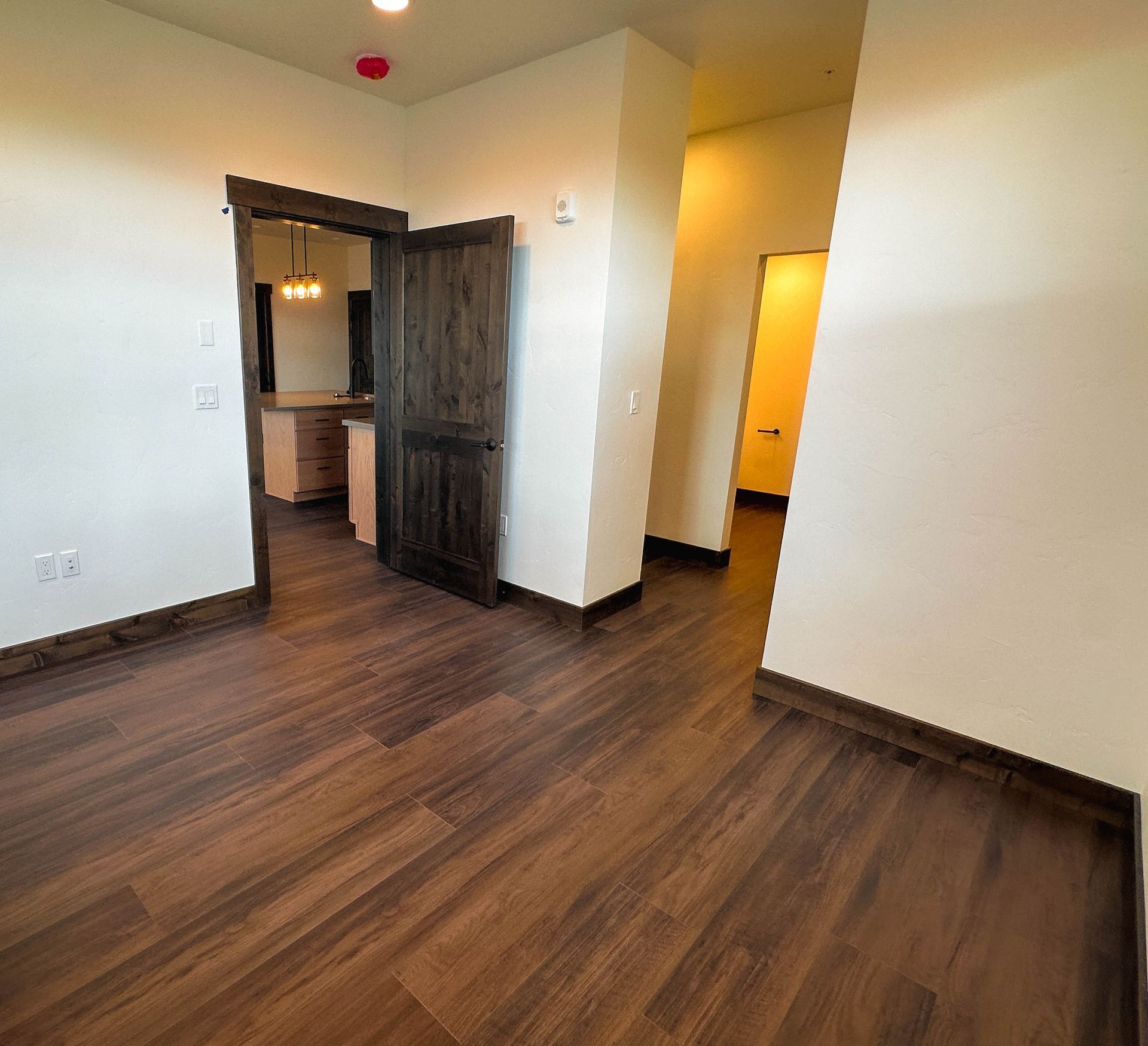 an empty room with hardwood floors and a wooden door