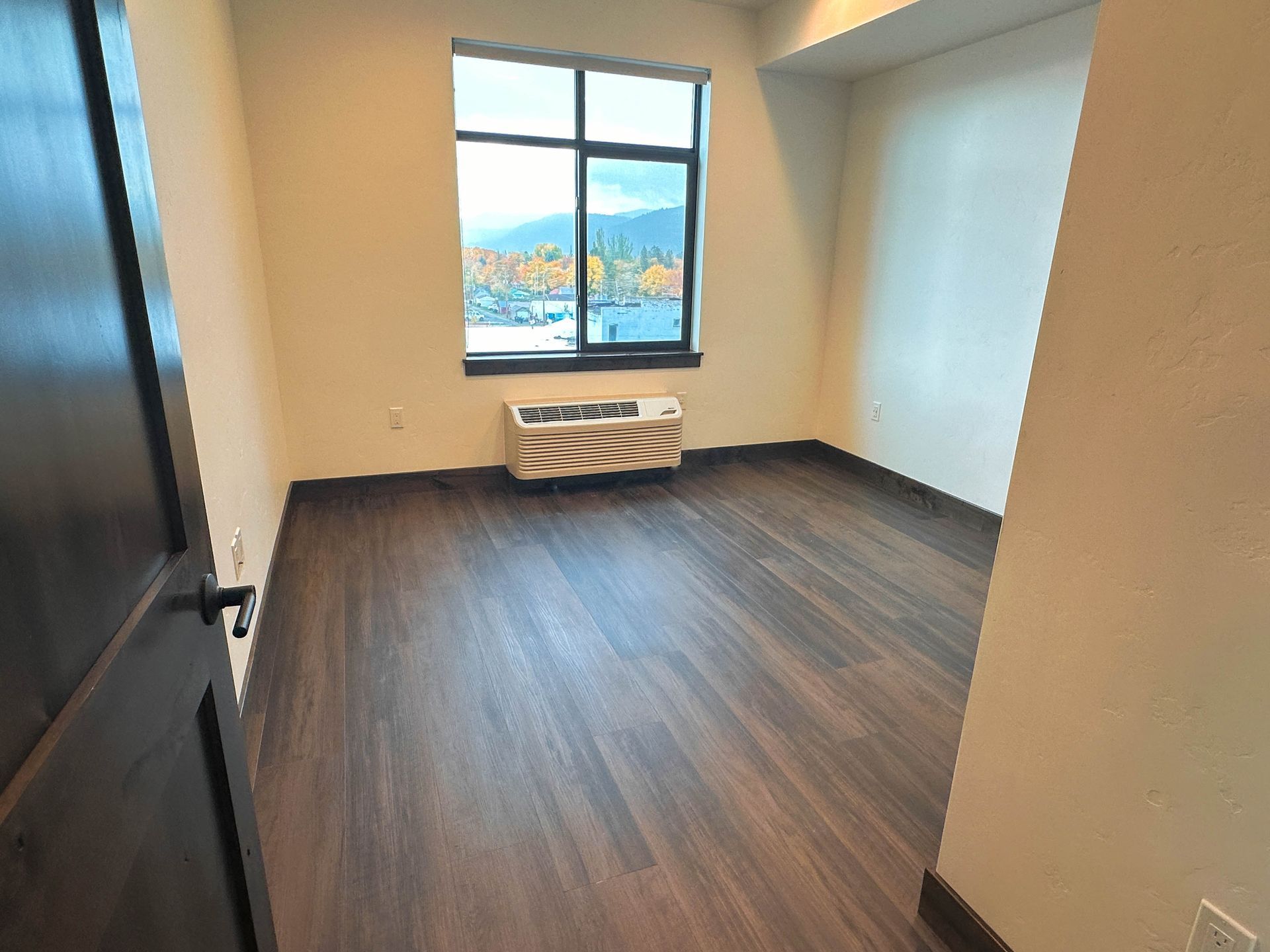 an empty room with a window and a heater