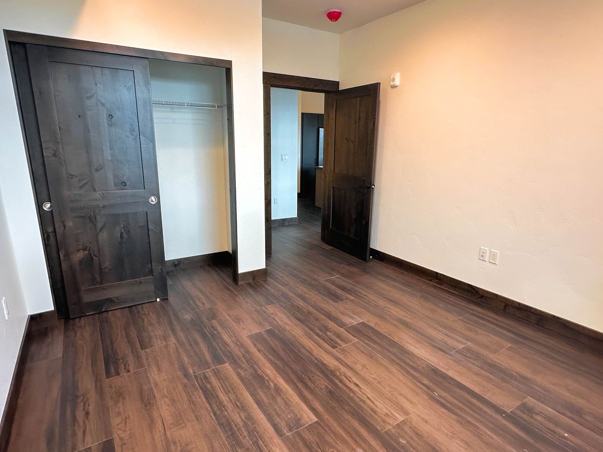 a bedroom with wooden floors and a closet