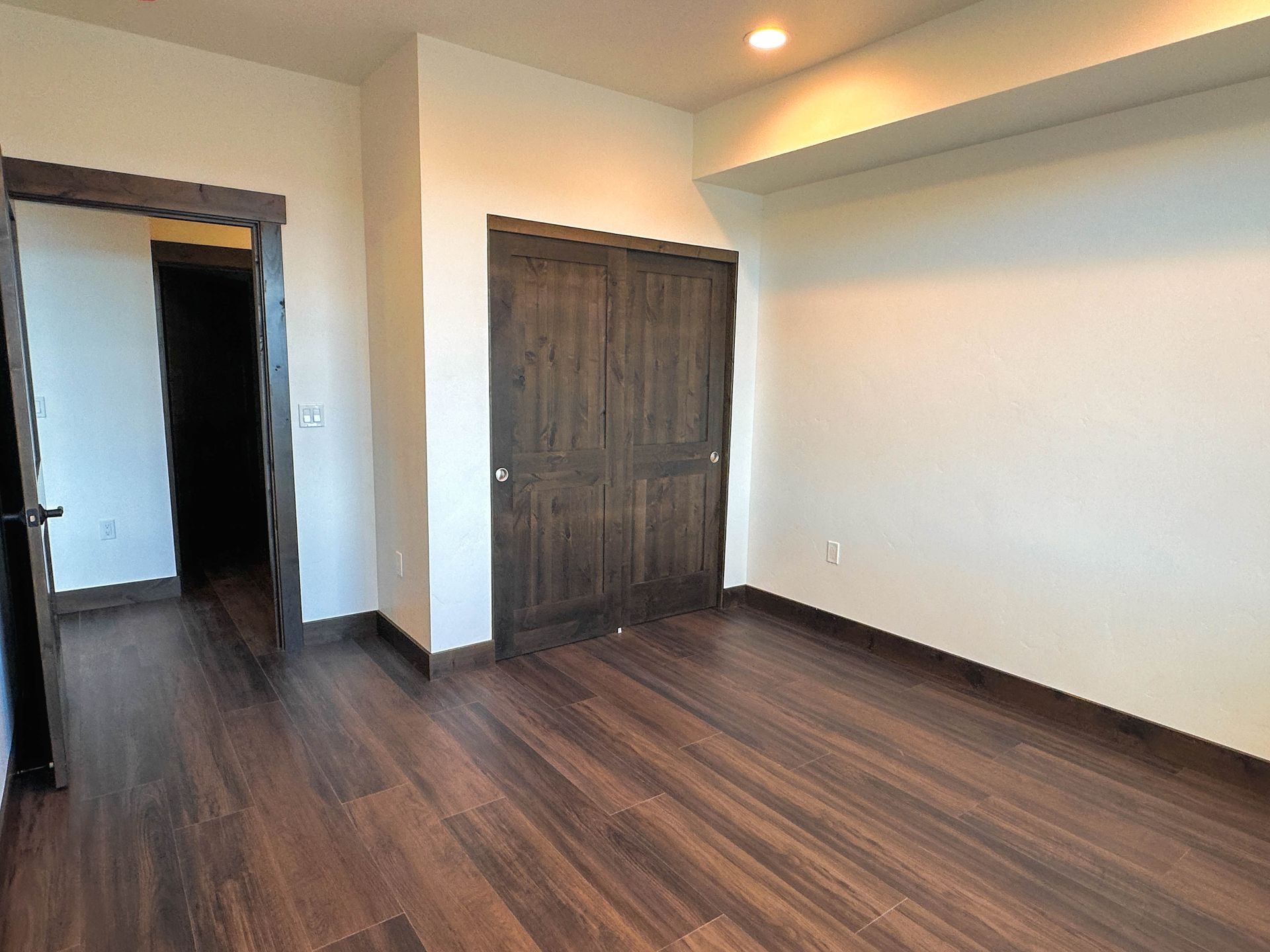 an empty room with wooden floors and a closet