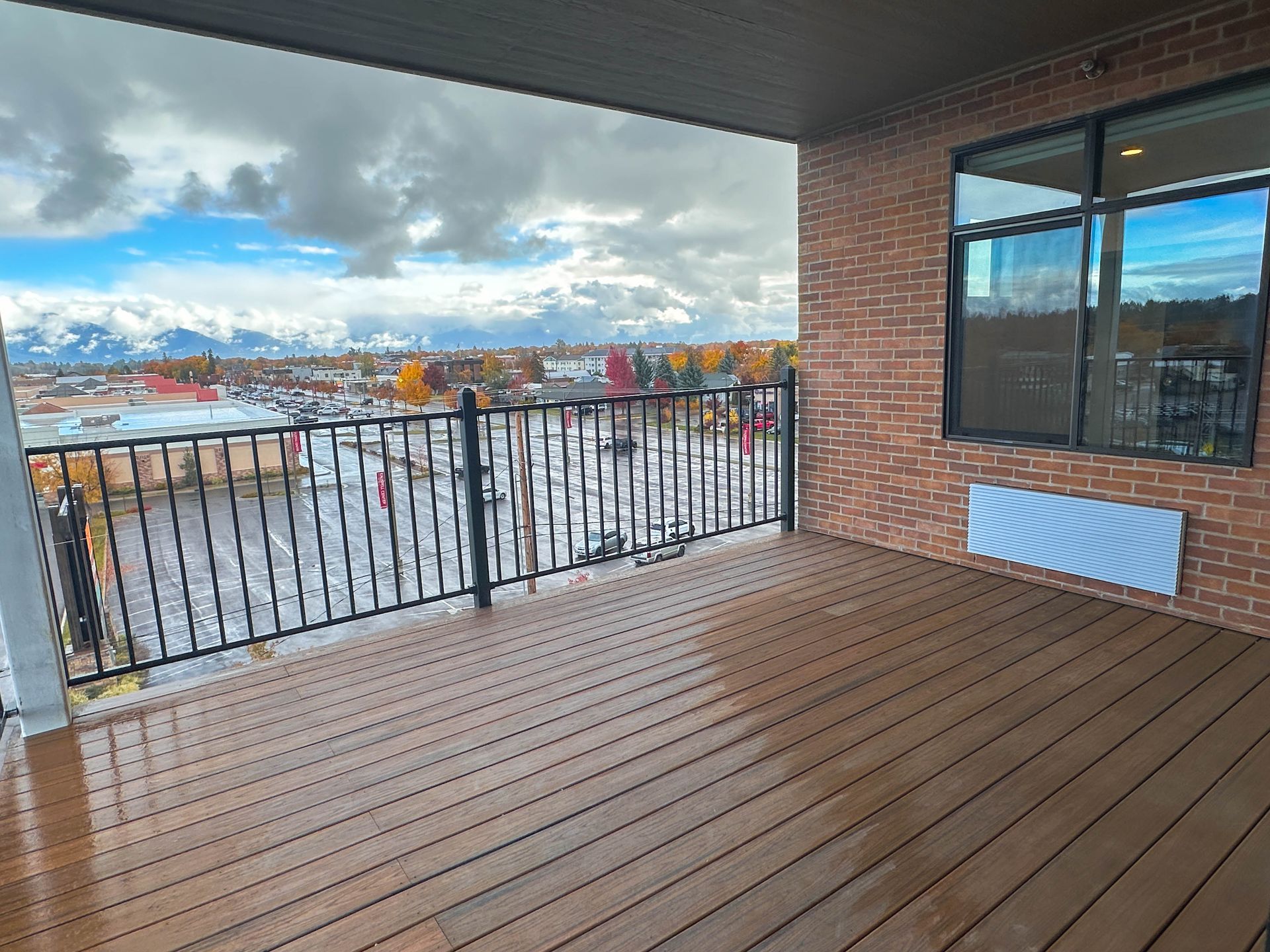 a balcony with a view of a parking lot and mountains