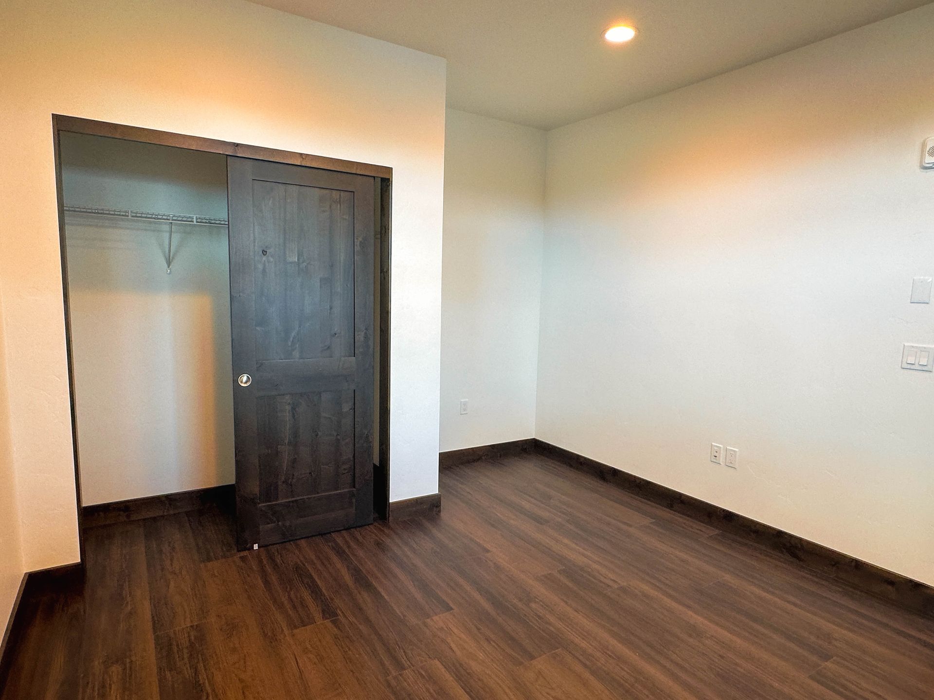 a closet with a wooden floor and a sliding door