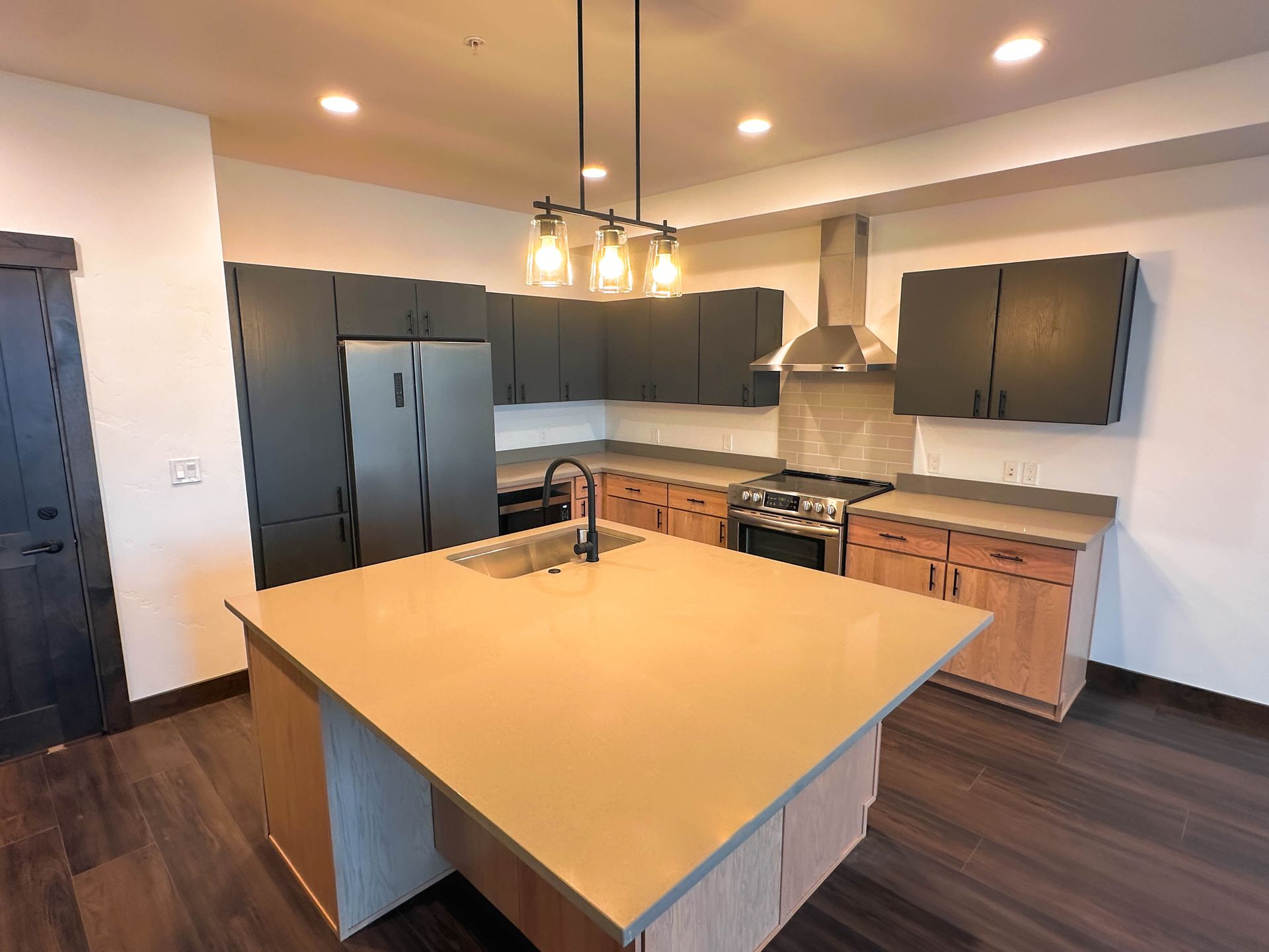 a kitchen with stainless steel appliances and black cabinets