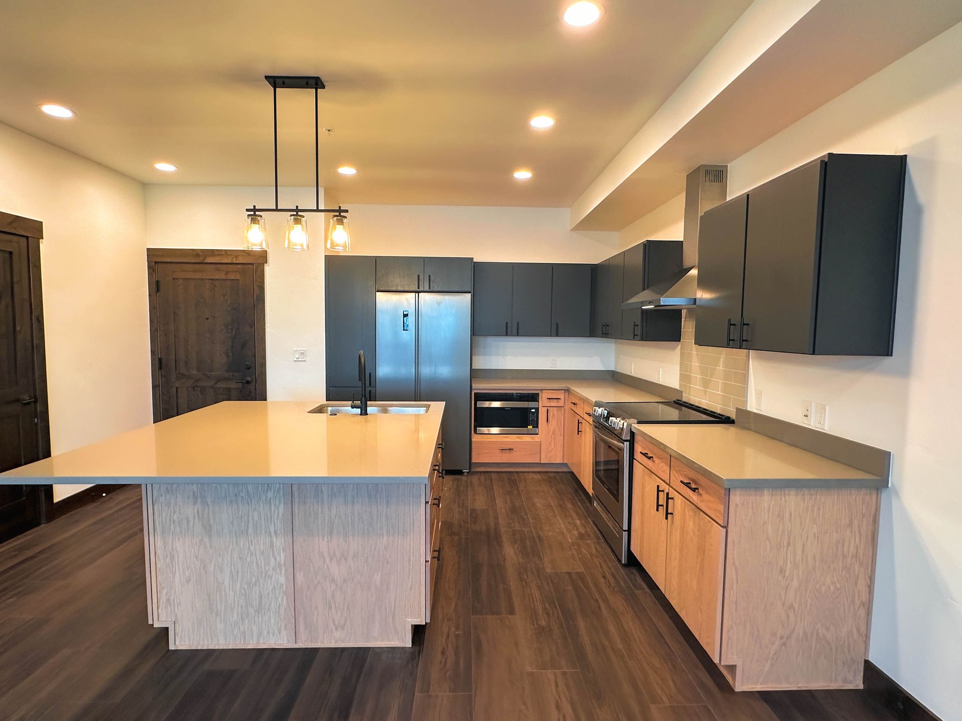a kitchen with a large island and stainless steel appliances