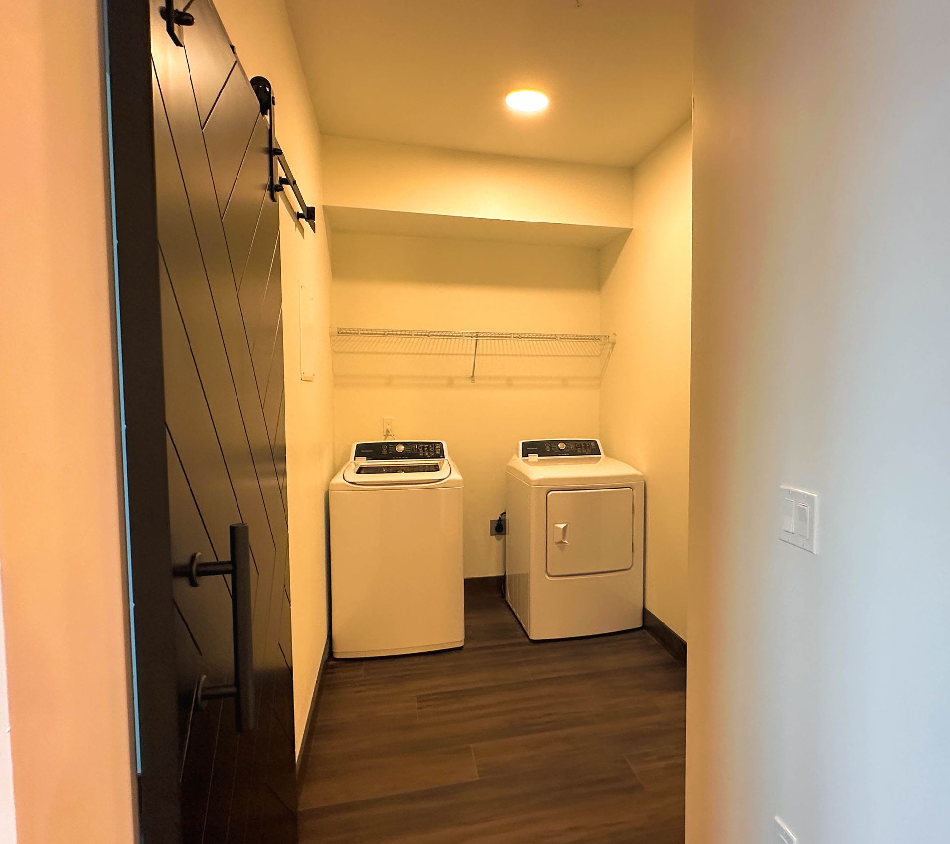a laundry room with a washer and dryer and a black door
