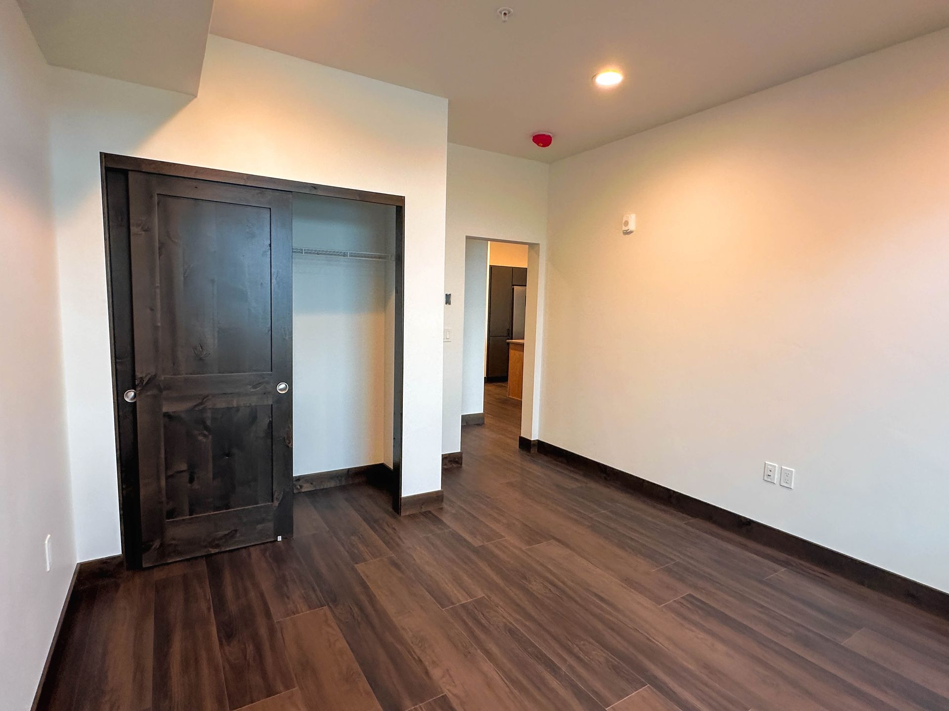 an empty room with a black door and a closet