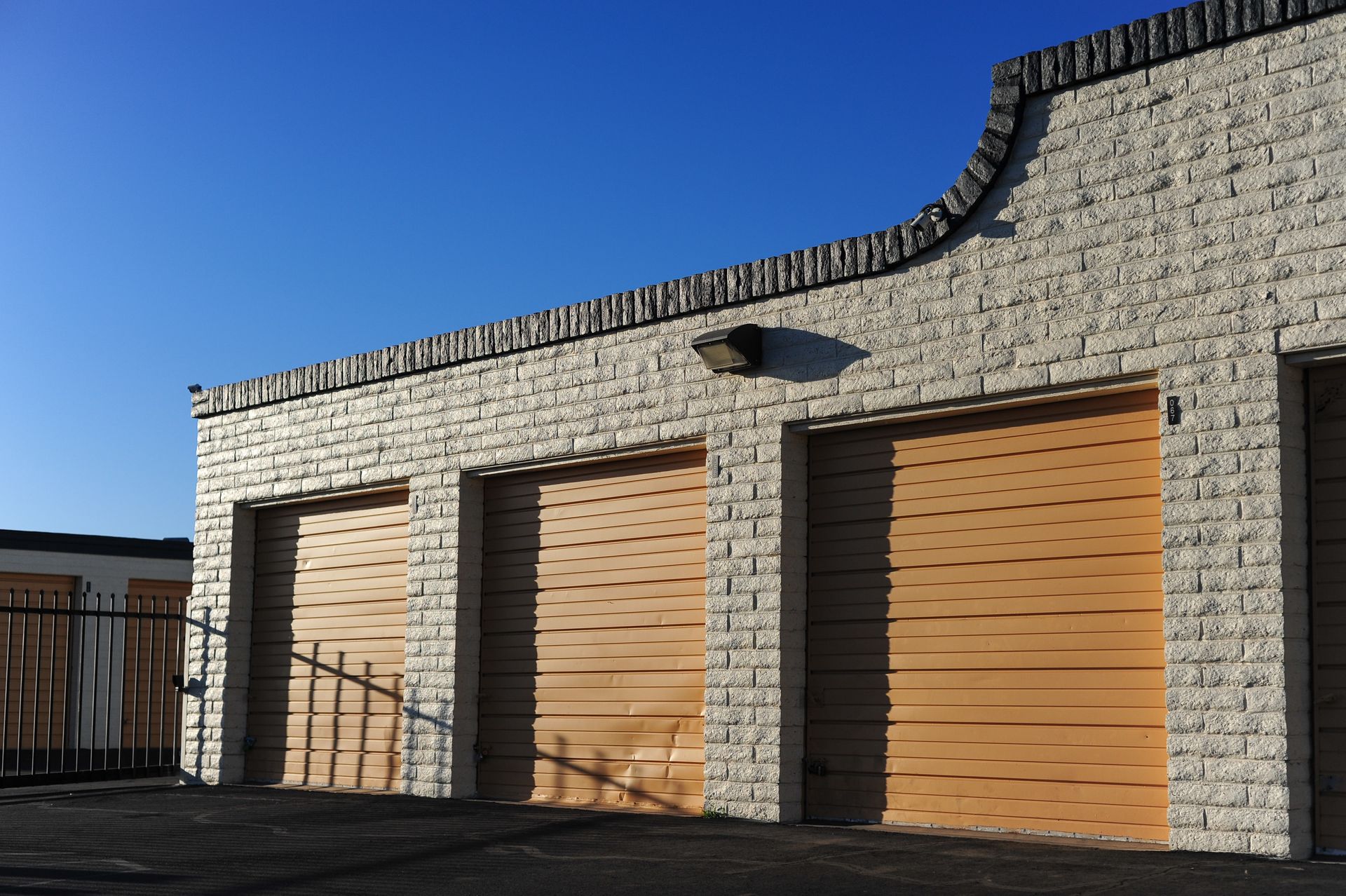 Exterior of a storage building with several closed roll up doors in bright daylight. Exterior of a storage building with several closed roll up doors in bright daylight.