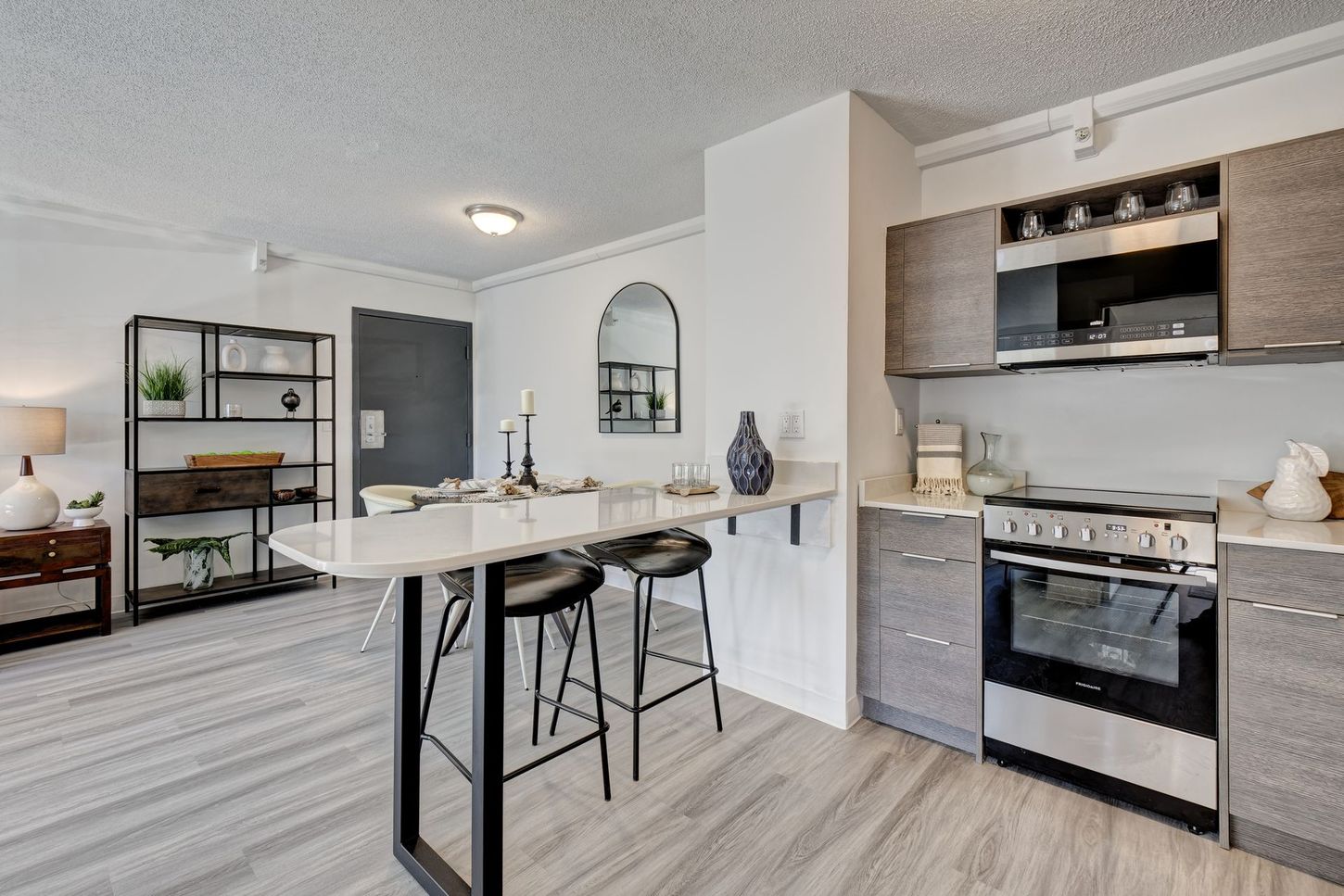 Modern kitchen with a breakfast bar, stainless steel appliances, and a dining area.