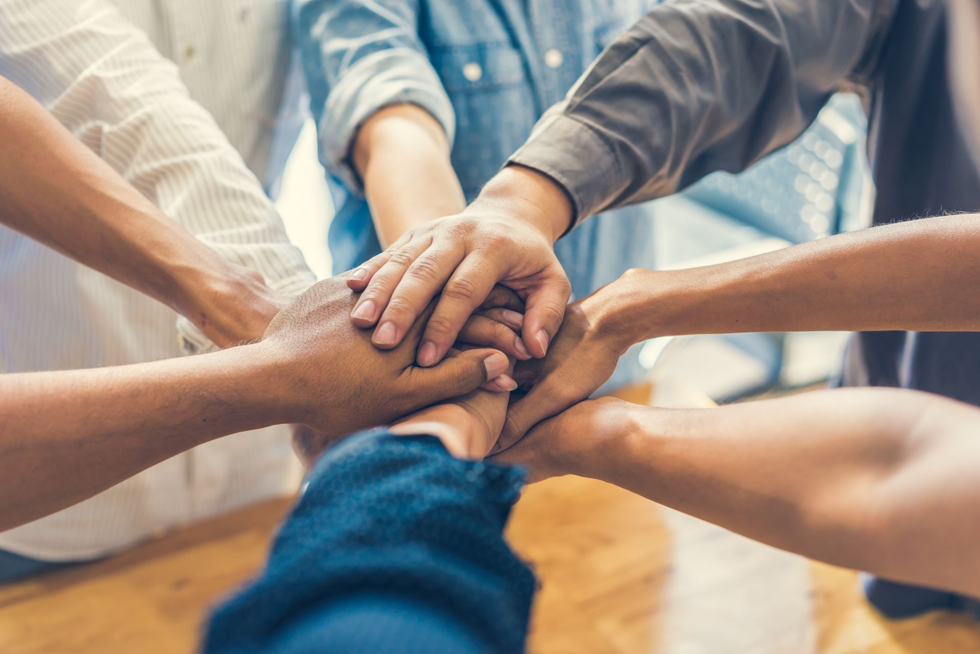 A group of people are putting their hands together in a circle.