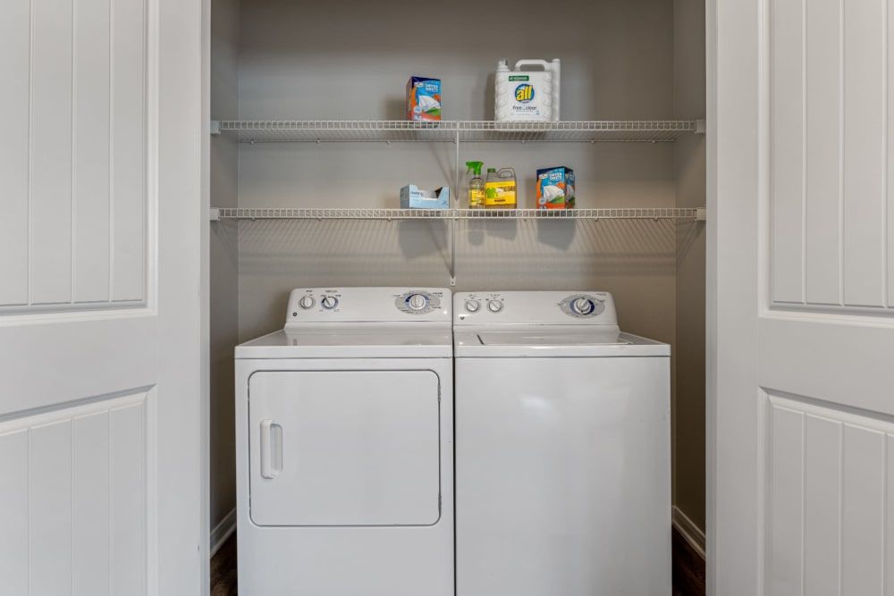 Apartment in-unit laundry room with a washer and dryer in a closet at Marquis at Sugar Land in Sugar Land, TX.
