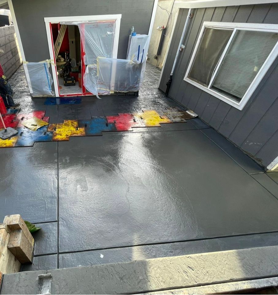 A Concrete Driveway Is Being Painted In Front Of A House — Daly City, CA — Turnil Construction, Inc.