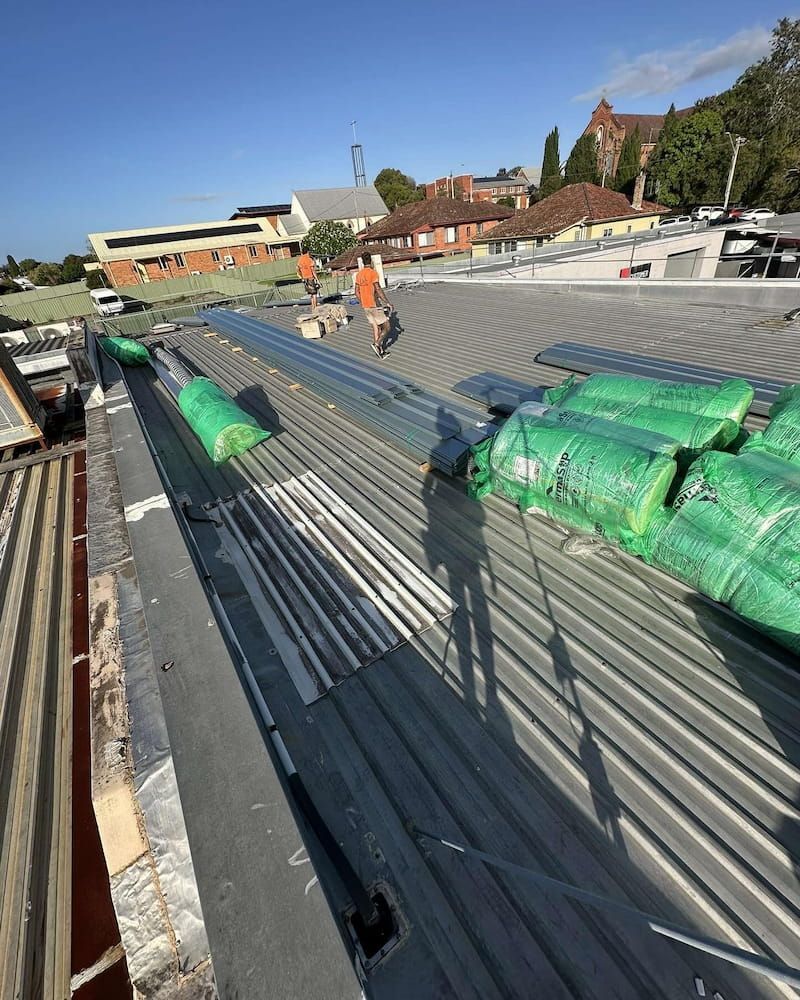 Construction Worker on a Rooftop Installing Corrugated Metal Sheets — Ace1 Metal Roofing in Taree, NSW
