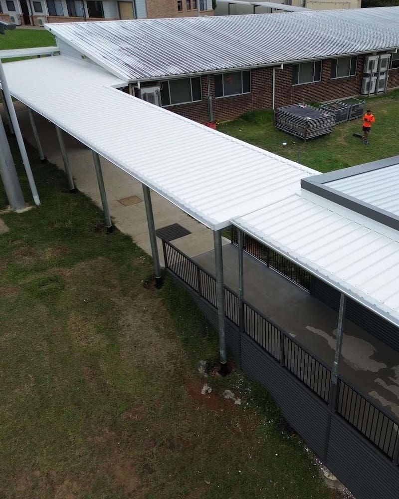 Overhead View of a White Roofed Walkway Alongside a Building — Ace1 Metal Roofing in Taree, NSW