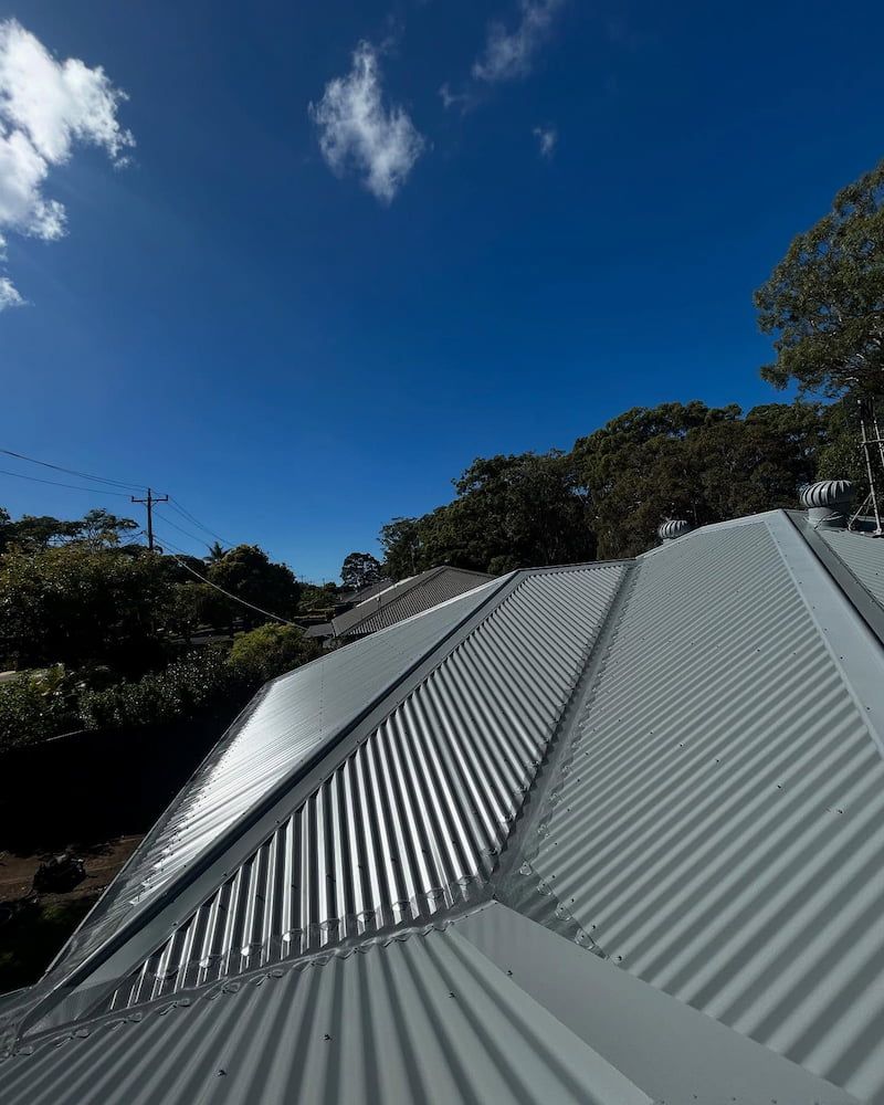 Blue Sky Over a Corrugated Metal Roof — Ace1 Metal Roofing in Taree, NSW