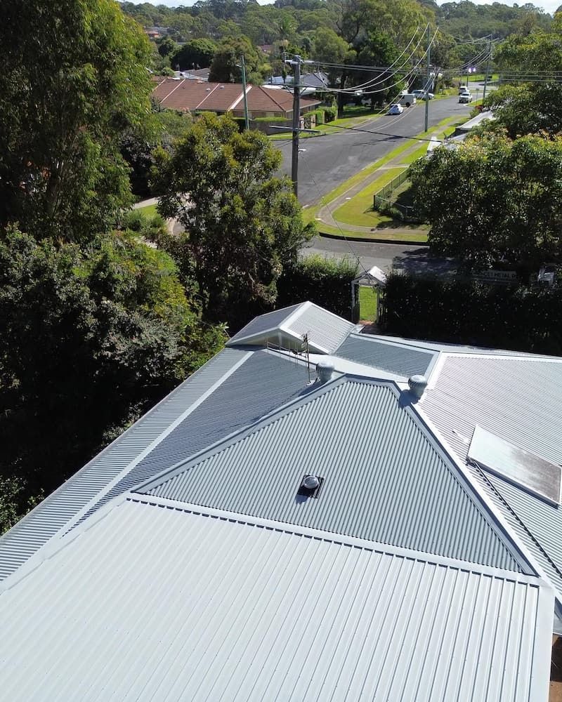 Grey Corrugated Metal Roof With a Street and Trees in the Background — Ace1 Metal Roofing in Diamond Beach, NSW