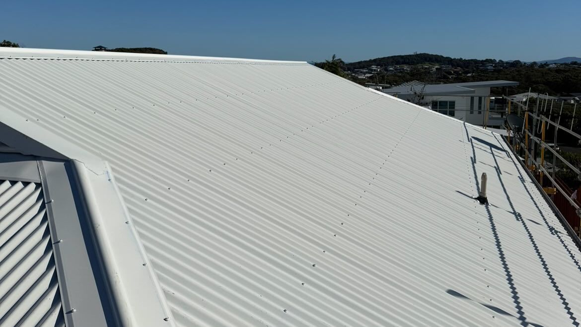 White Corrugated Metal Roof on a Sunny Day, With Scaffolding Visible on the Side — Ace1 Metal Roofing in Taree, NSW