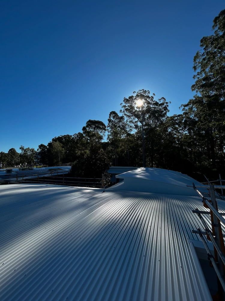 Sunlight Shines on a Corrugated Metal Roof, Casting Long Shadows — Ace1 Metal Roofing in Port Macquarie, NSW