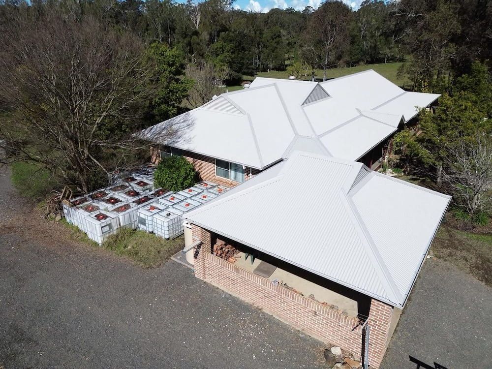 Aerial View of a Brick House With a White Roof — Ace1 Metal Roofing in Laurieton, NSW
