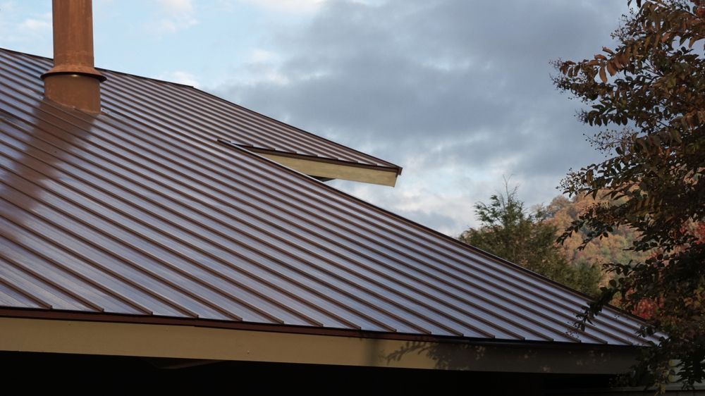 Brown Metal Roof With Chimney Against a Cloudy Sky — Ace1 Metal Roofing in Gloucester, NSW