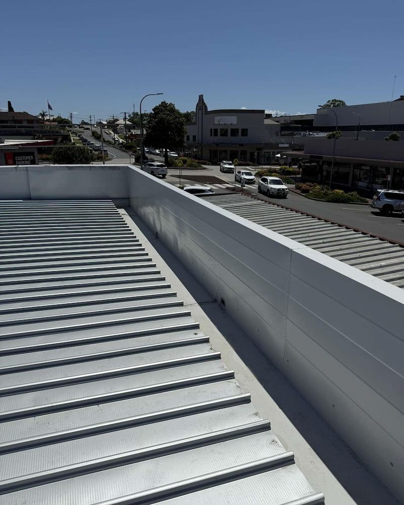 View From a Rooftop, Showing a Road With Cars, Buildings, and a Clear Blue Sky — Ace1 Metal Roofing in Taree, NSW
