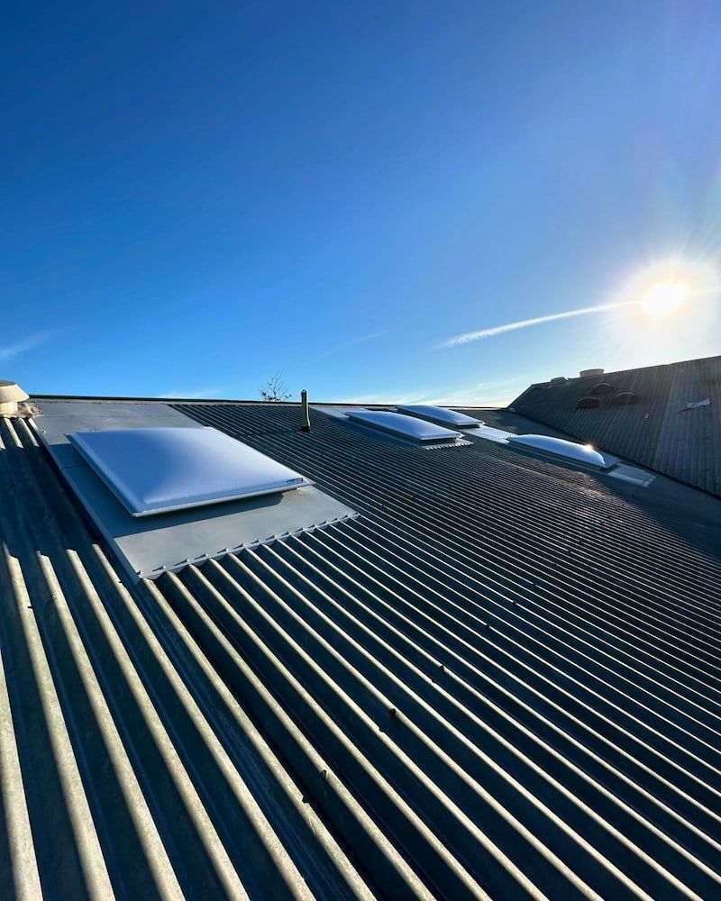 Metal Roof With Multiple Skylights Under a Bright Blue Sky and Sunshine — Ace1 Metal Roofing in Old Bar, NSW