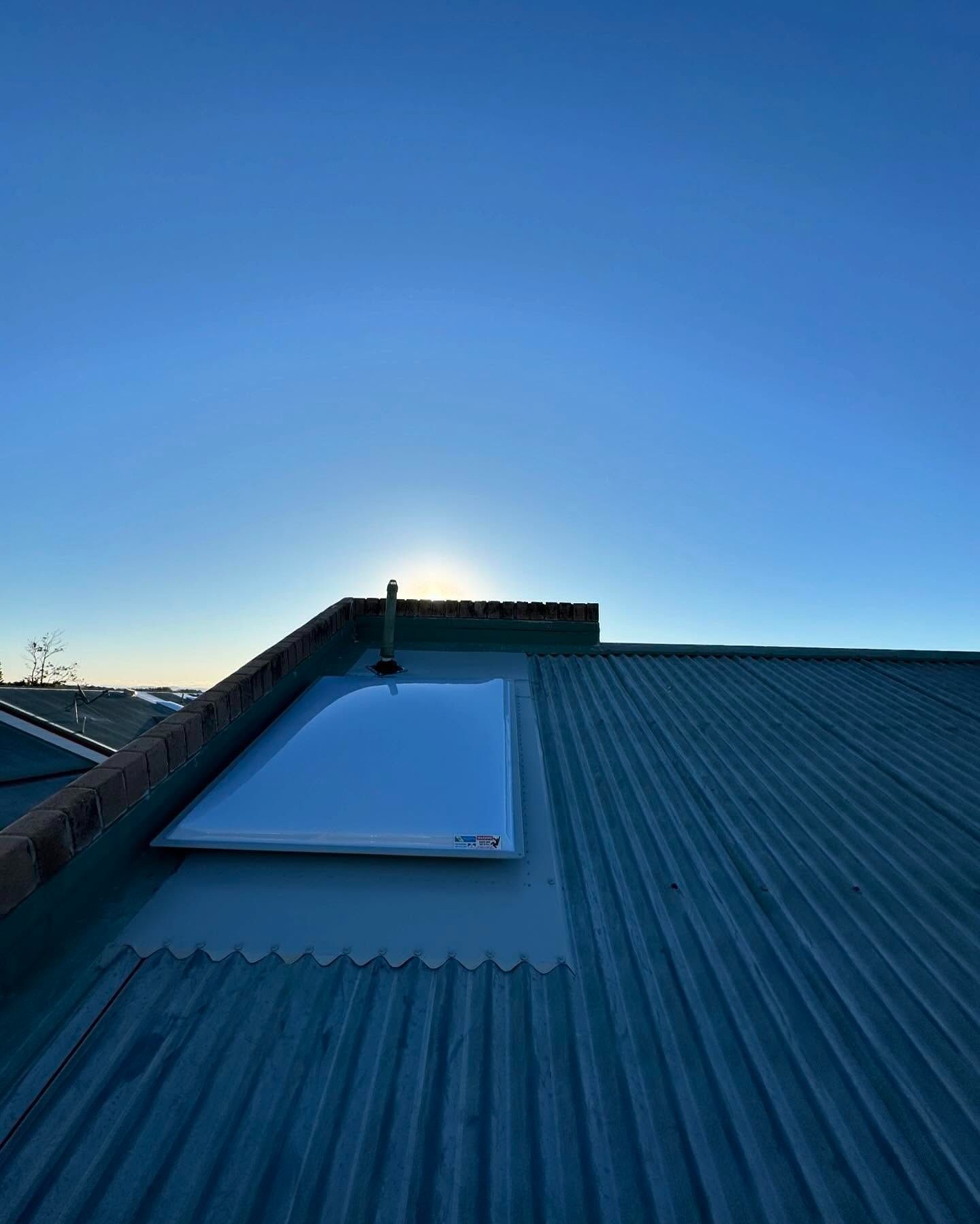 Skylight on a Corrugated Metal Roof With the Sun Setting in the Background — Ace1 Metal Roofing in Harrington, NSW