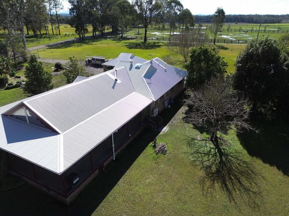 Aerial View of a House With a Silver Roof on a Green Lawn — Ace1 Metal Roofing in Taree, NSW
