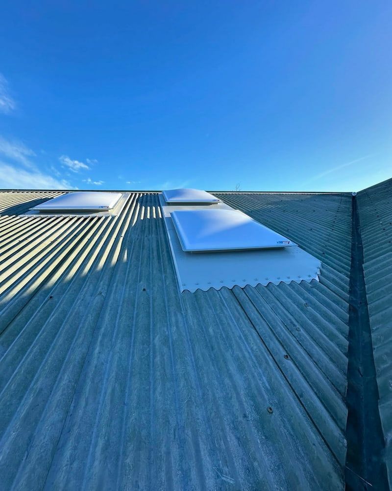 Three Skylights on a Corrugated Metal Roof Against a Bright Blue Sky — Ace1 Metal Roofing in Gloucester, NSW