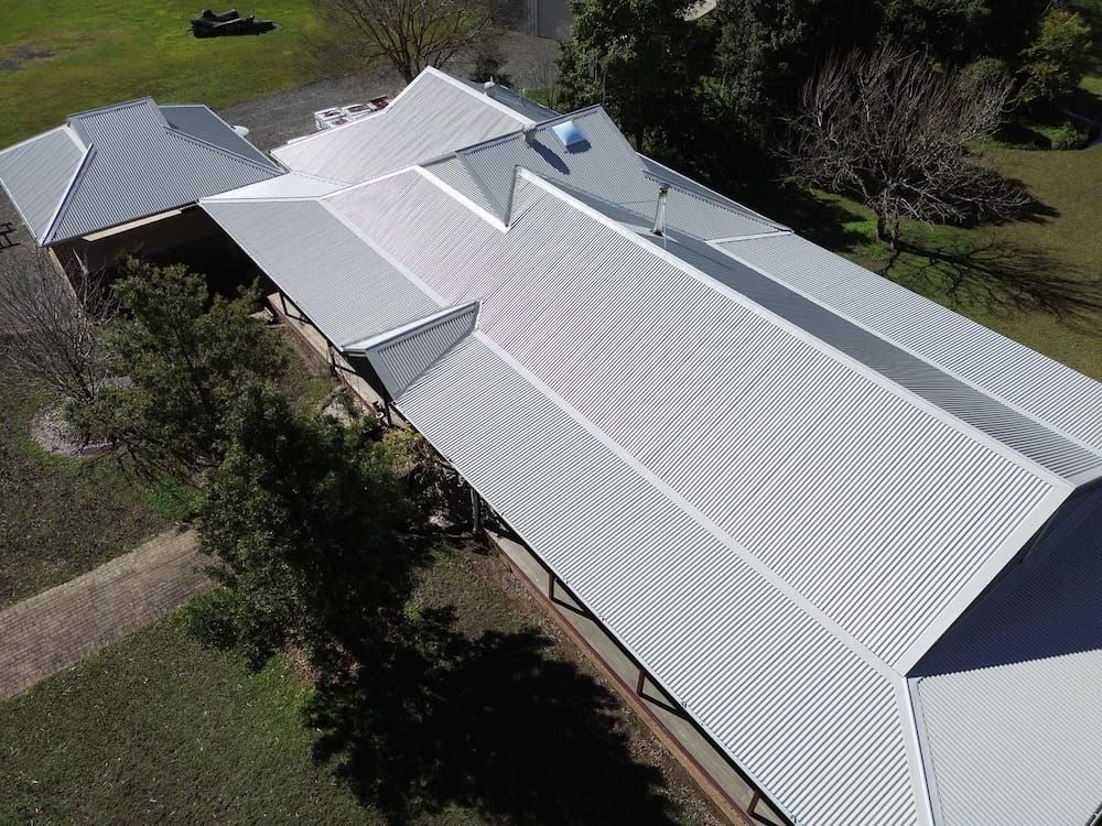 Aerial View of a Building With a Corrugated Metal Roof in a Grassy Area — Ace1 Metal Roofing in Taree, NSW