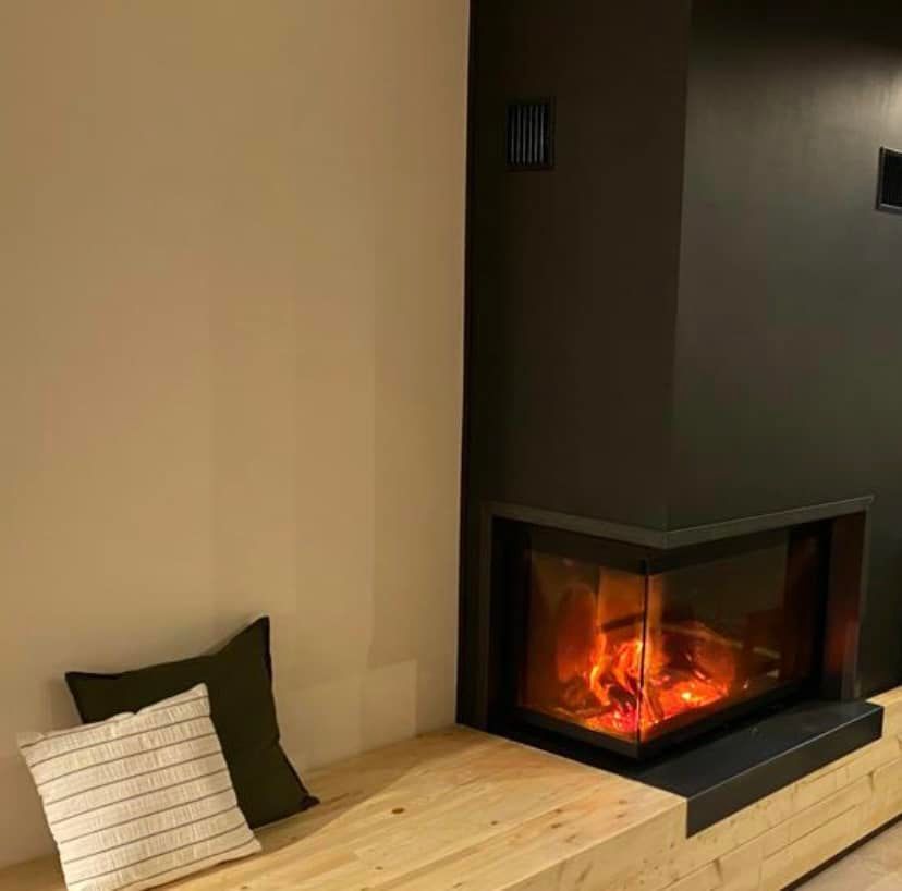 un soggiorno con camino e panca in legno.