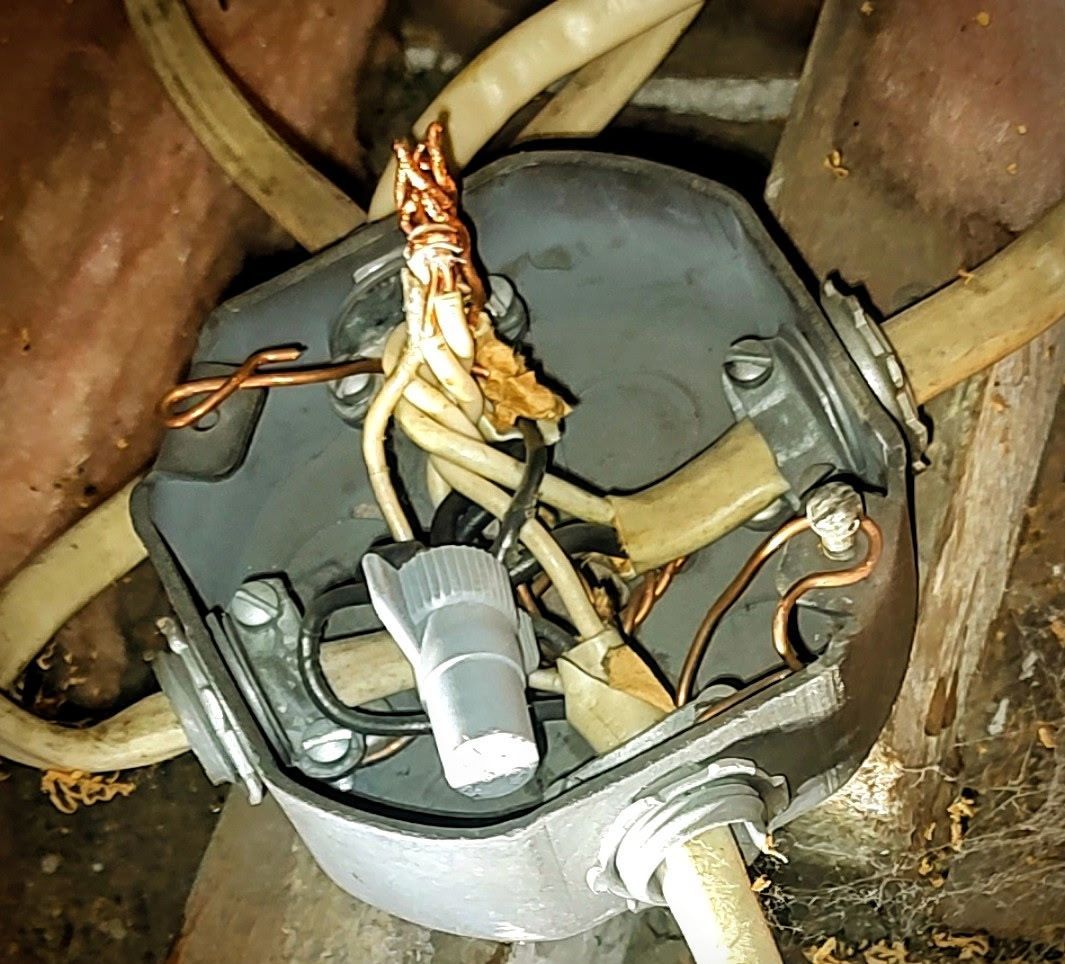 Open electrical junction box with exposed wires and wire connectors.