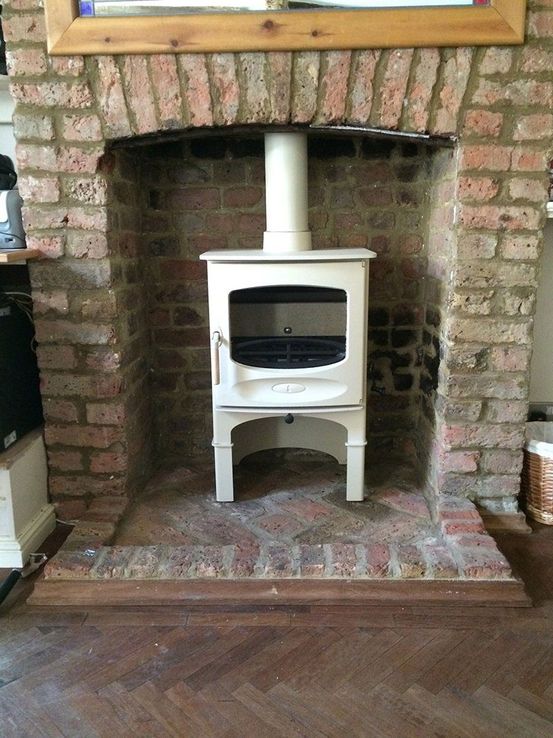 Stove fitted in a brick fireplace