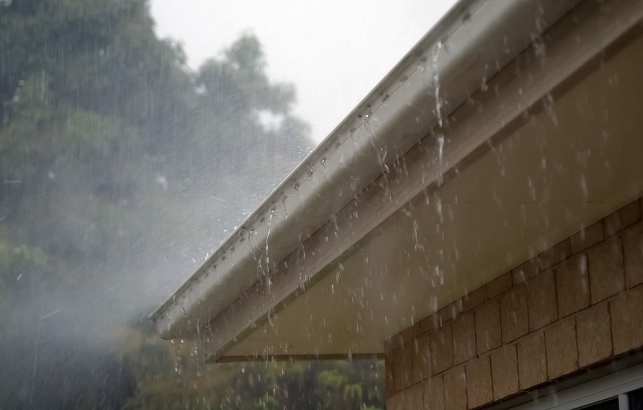 It is raining on the roof of a house.