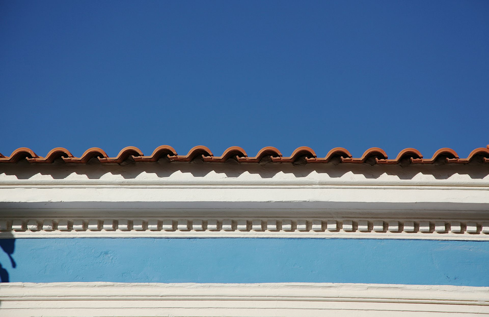 The roof of a building with a blue sky in the background