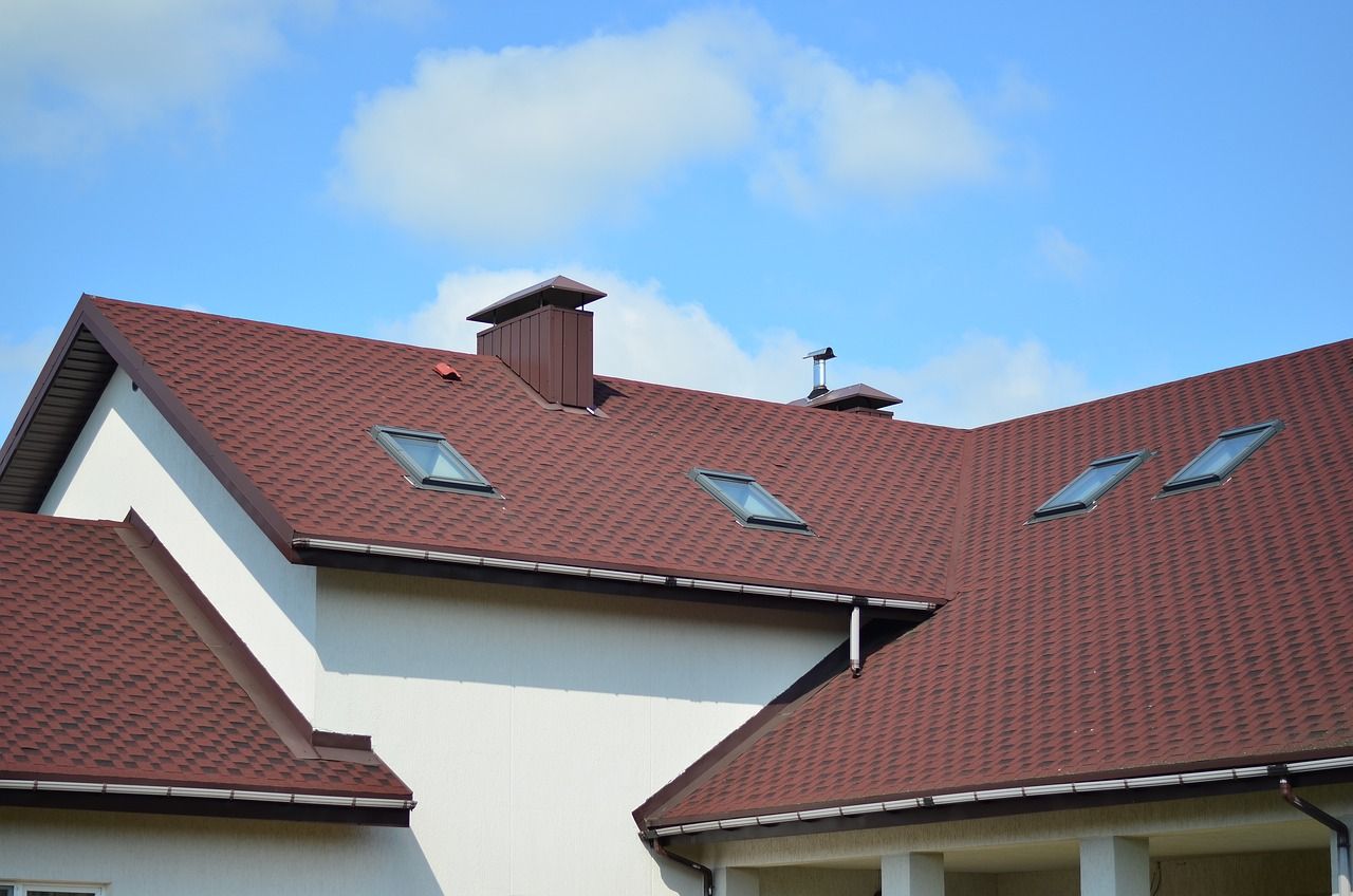 A house with a red roof and skylights on it.