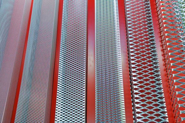 A row of metal bars sitting on top of each other on a red surface.