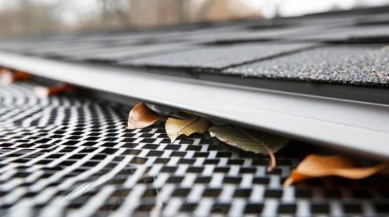 A roll of black mesh is sitting on top of a gutter.