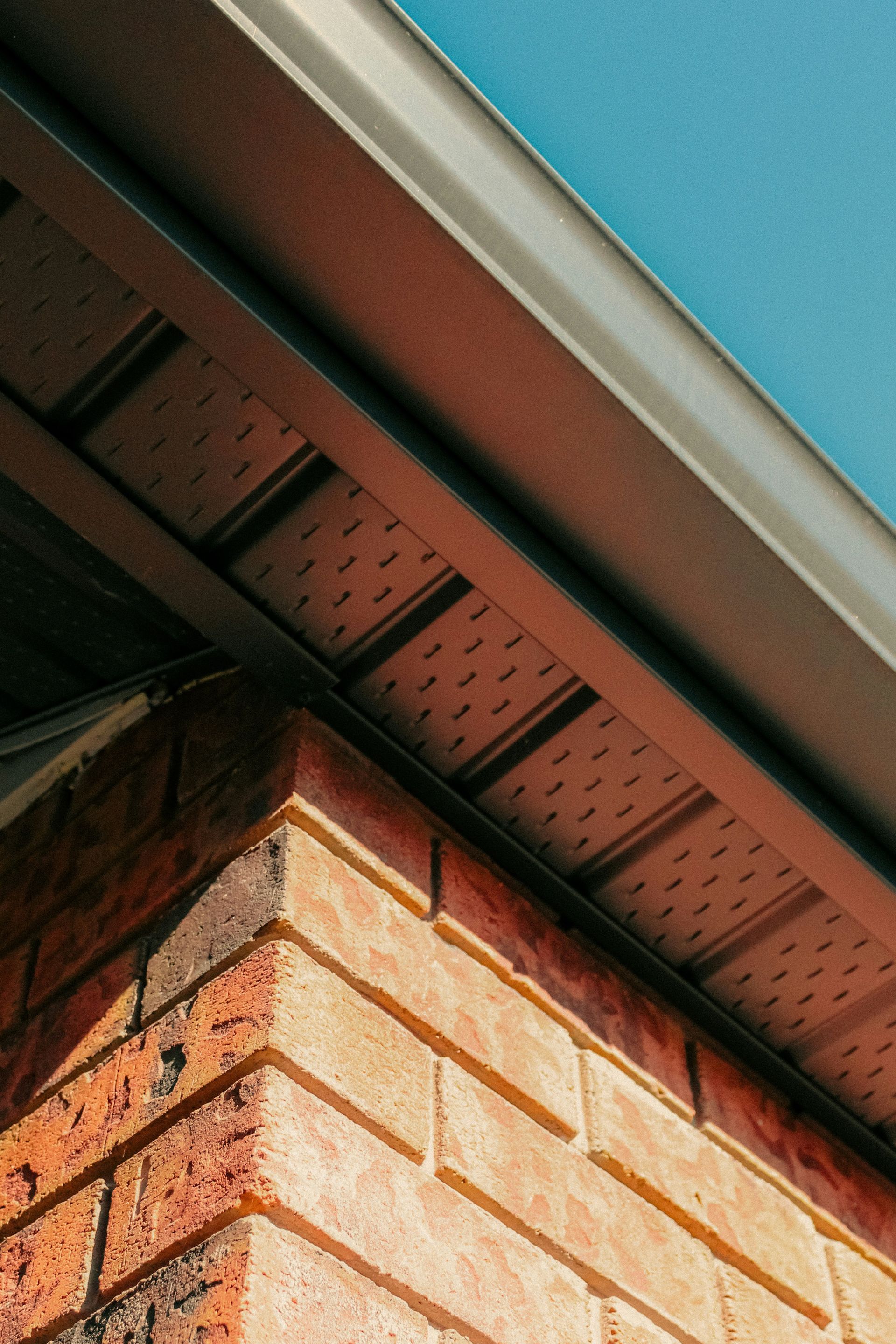 A brick wall with a gutter on top of it