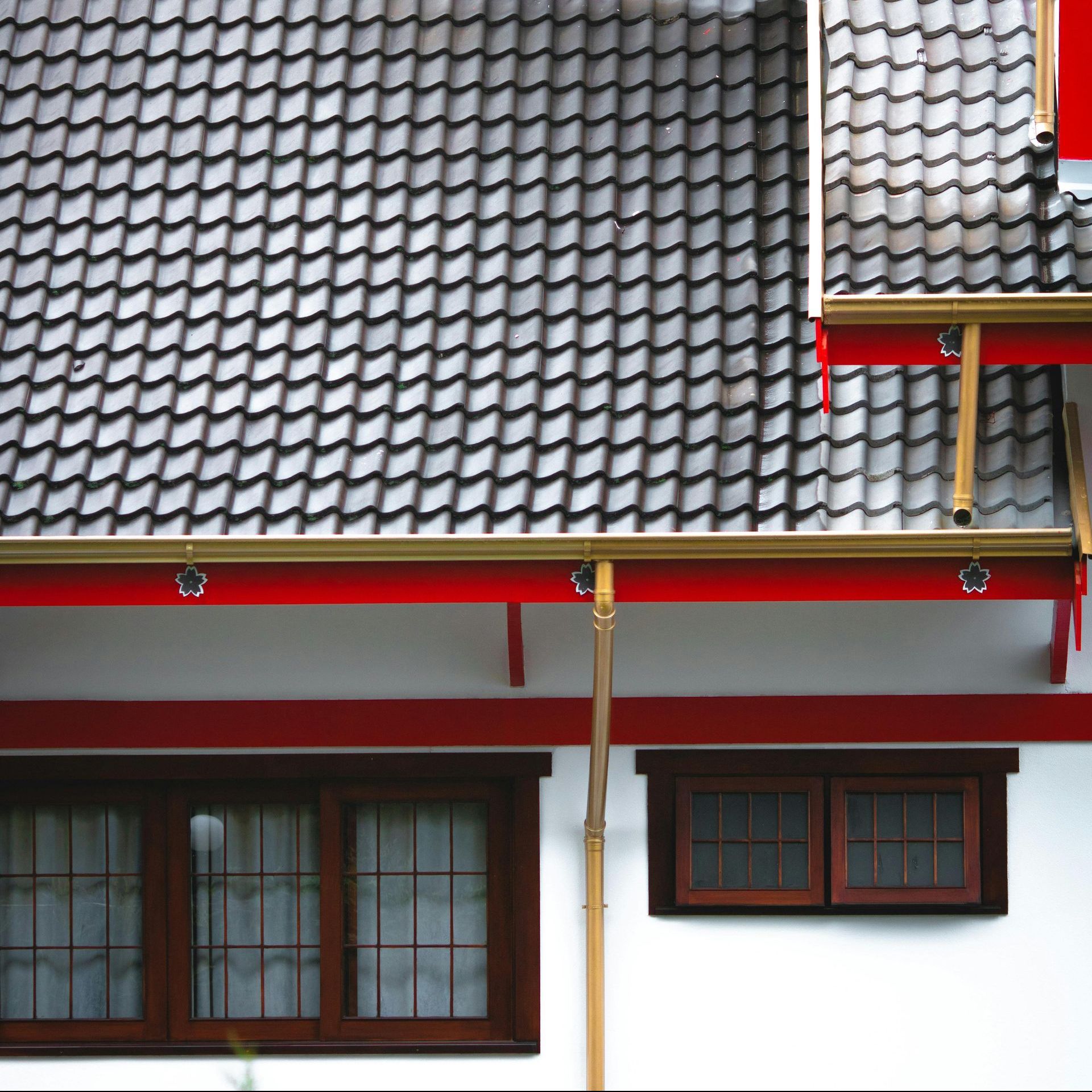 An aerial view of a person walking down a driveway next to a house with gutters.