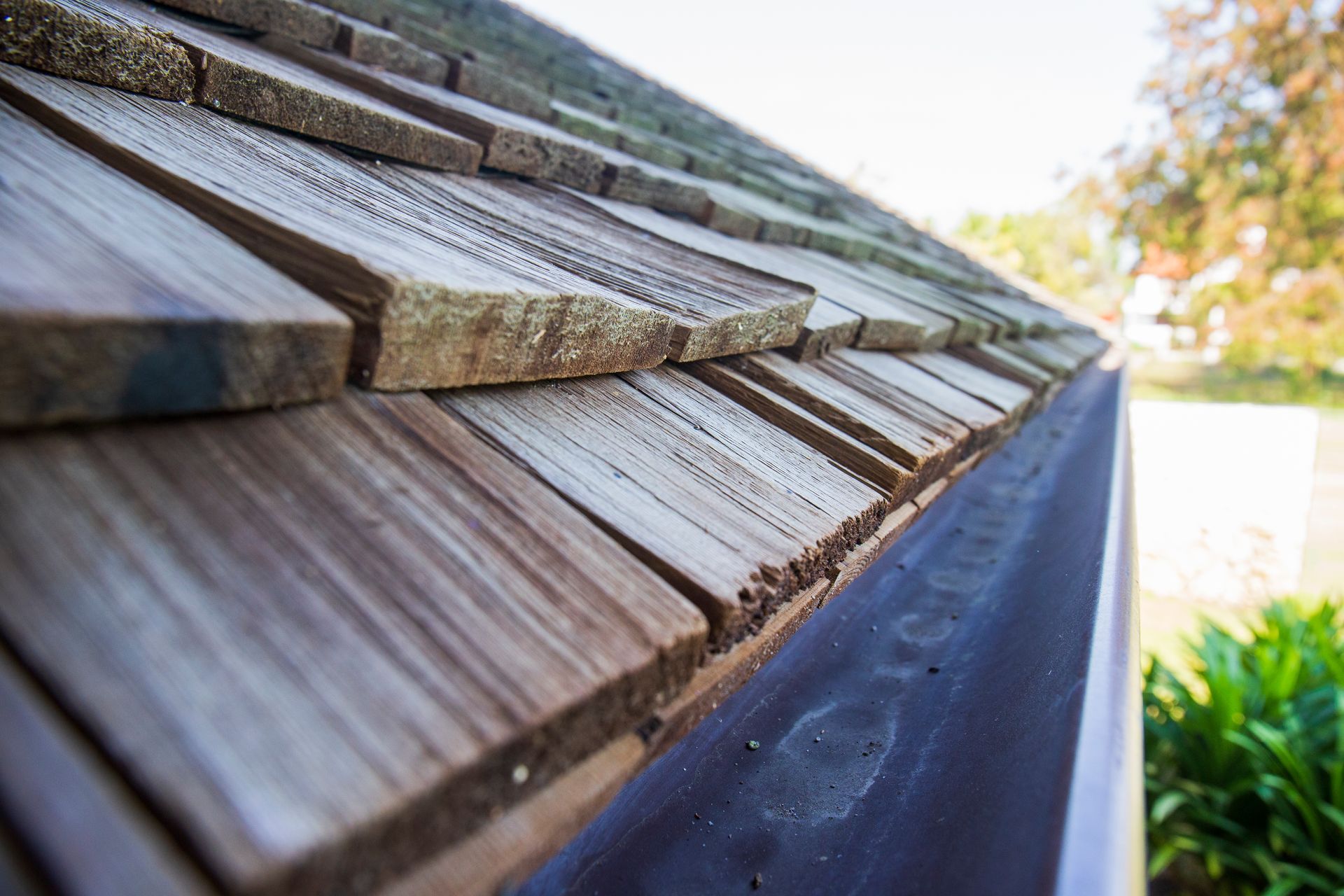 A close up of a wooden roof with a black gutter.