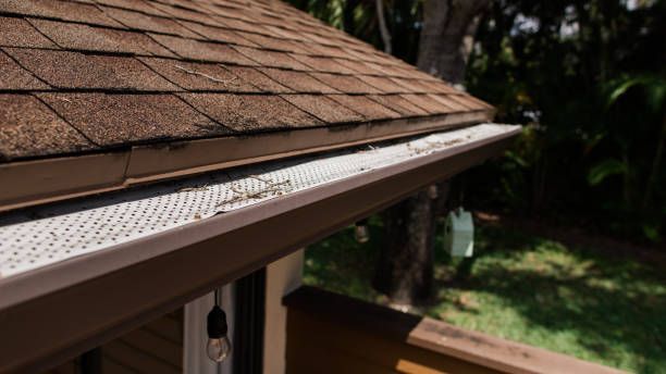 A close up of a gutter on the side of a house.